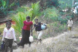 Sri Lankan women carrying water for kilometres to their village.